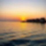 A panoramic view of Umm Al Quwain's coastline at sunset, showcasing the vibrant colors reflecting on the water.